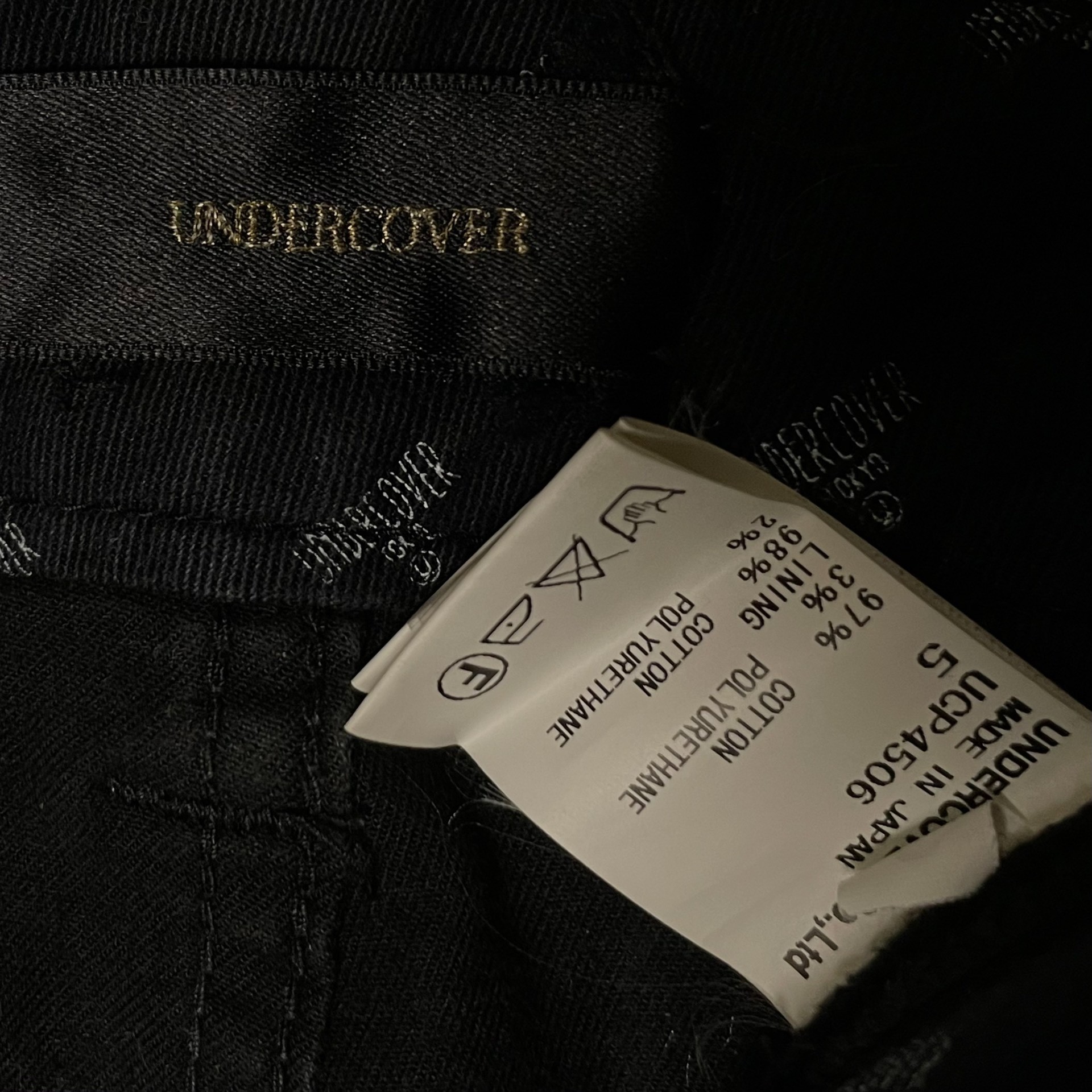 Undercover Black Distressed Jeans — label