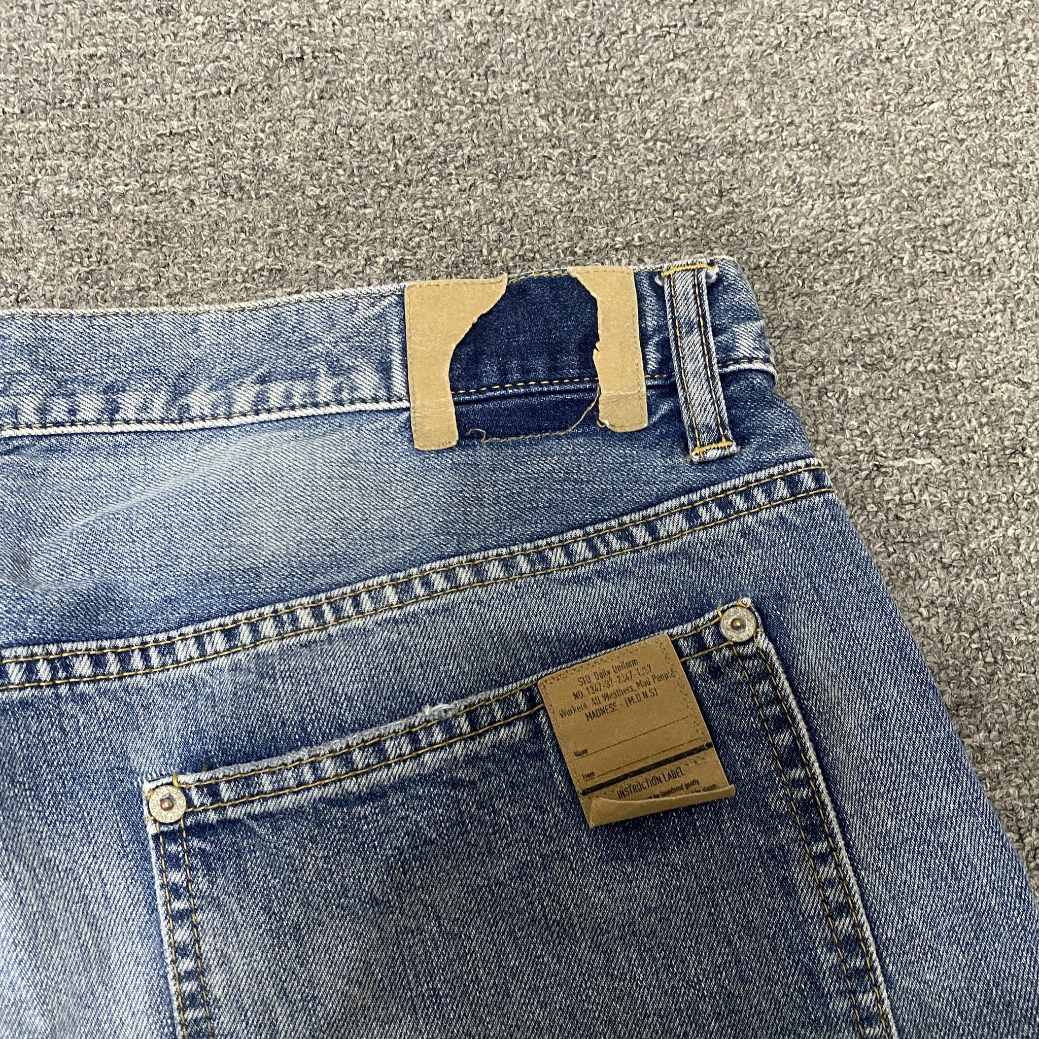 MADNESS 22SS Dual-Cut Blue Jeans — label