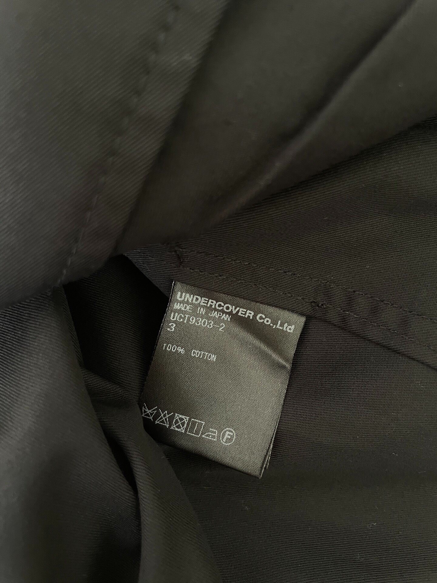 UNDERCOVER Skoloct Black Coat — label