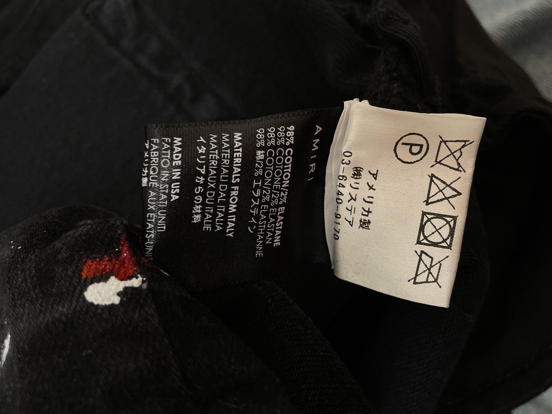 Amiri Splatter Distressed Black Jeans — label
